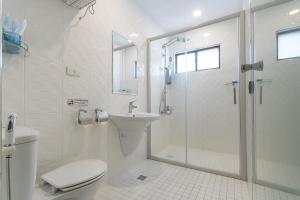 a bathroom with a shower and a toilet and a sink at Just Enjoy Business Hotel in Tainan