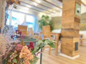 a dining room with a table with flowers on it at LANDHOTEL 1707 by Landgasthof Zickler in Gleisweiler