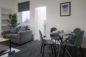 uma sala de estar com uma mesa e cadeiras e um sofá em Troon Golf Apartment em Troon