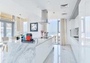 a kitchen with white marble countertops and large windows at Luxury 2 BR Beachfront Apt with maids room in the heart of Bluewaters Island in Dubai