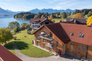 an aerial view of a house with a lake at Seehotel und Appartements Schnöller in Rieden am Forggensee