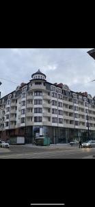 un grand bâtiment blanc avec des voitures garées devant lui dans l'établissement Apartment in Khmelnytsky Street, à Lviv