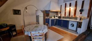 cocina con mesa y cocina con armarios azules en hebergement-luxeuil-les-bains, en Luxeuil-les-Bains