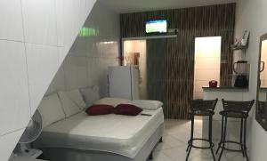 a room with a bed and some chairs and a tv at Kitnets da vana in Morro de São Paulo