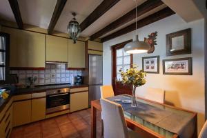 a kitchen with a table with a vase of flowers on it at Chalet Nº 7 Tajinaste in Puerto del Carmen
