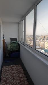 a room with windows and a bed and a couch at Уютные апартаменты в историческом центре in Aktobe