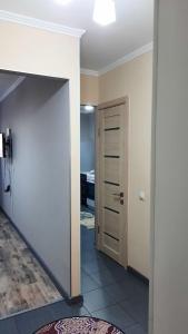 einen Flur mit einer Tür, die zu einem Zimmer führt in der Unterkunft Уютные апартаменты в историческом центре in Aqtöbe