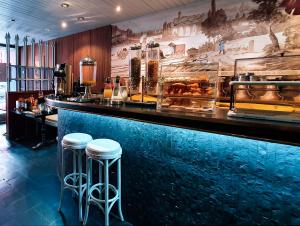 a bar with two stools in front of a counter at Terminus du Forez Saint-Etienne Centre Gare Chateaucreux in Saint-Étienne