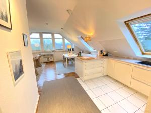 an attic kitchen with white cabinets and a table at Kieler FeWo No.1 in Kiel