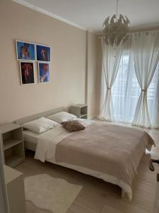 una camera da letto bianca con un letto grande e una finestra di Beautiful Colors Residence Villa a Otopeni