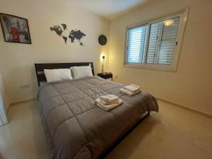 Un dormitorio con una cama grande con dos toallas encima. en 3Bdr apt Pizza Hut By Platform 357, en Strovolos