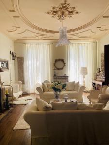 una sala de estar con muebles blancos y una lámpara de araña. en Vieille rose, en Niort