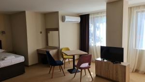 ein Hotelzimmer mit einem Bett, einem Tisch und Stühlen in der Unterkunft Hotel Geppy in Sofia