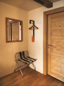 a room with a chair and a mirror and a door at Kupfernams in Ventspils