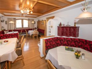 ein Restaurant mit roten Sitzgelegenheiten und Tischen in einem Zimmer in der Unterkunft Pension und Appartement Weinschreiber in Rauris