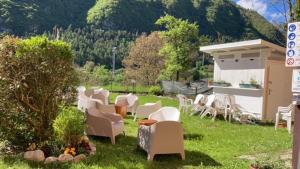 eine Gruppe von Stühlen und Tischen in einem Hof in der Unterkunft Garni Le Prealpi in Ledro