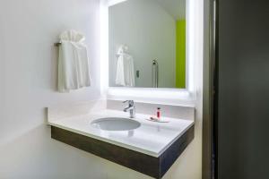 a bathroom with two sinks and a mirror at Super 8 by Wyndham Winnipeg East MB in Winnipeg