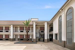 a building with a palm tree in the courtyard at Super 8 by Wyndham Houston Downtown I-610 in Houston