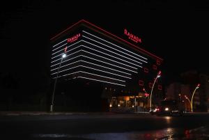a building with a sign on the side of it at night at Ramada Usak in Uşak