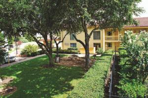 a park with a bench and trees in front of a building at Baymont by Wyndham Houston La Porte in La Porte +7 photos