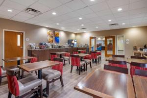 a restaurant with wooden tables and red chairs at Comfort Inn Louisville Southwest in Louisville
