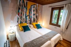 sypialnia z 2 łóżkami z żółtymi i niebieskimi poduszkami w obiekcie LA CASETA Turismo Rural w mieście Morella