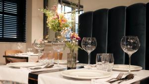 a table with wine glasses and plates on it at Sientjes Boetiekhotel in Kerkdriel