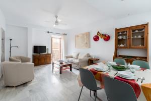 ein Wohnzimmer mit einem Tisch, Stühlen und einem Sofa in der Unterkunft Veoapartment San Marcos in Sevilla