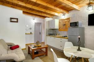 a kitchen and a living room with a couch and a table at Casa Rural Los Colorados in Vega de San Mateo