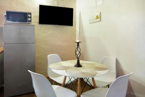 een eetkamer met een tafel en stoelen en een televisie bij Casa Rural Los Colorados in Vega de San Mateo