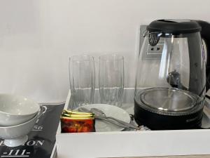 a kitchen counter with two glasses and a blender at Kaspi Hotel in Oral