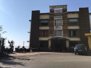 un edificio con un'auto parcheggiata di fronte di Little Mastiff Pong View a Dharamshala