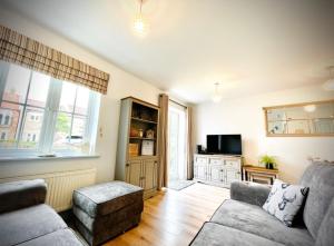 a living room with a couch and a tv at The Bay, Filey, Moonshine Cottage in Filey