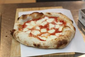 a small pizza sitting on top of a cutting board at Hotel Czerniewski in Warsaw