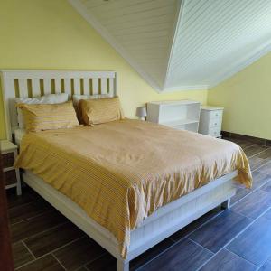 a bedroom with a large bed with a wooden floor at African Sunset Villa in Chintsa +19 photos
