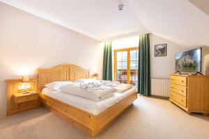 a bedroom with a large bed and a television at Apparthaus Sonnenberg in Haus im Ennstal