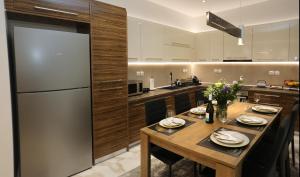 kuchnia z drewnianym stołem i lodówką w obiekcie LA Larissa Luxury Apartments Peneus w mieście Larisa