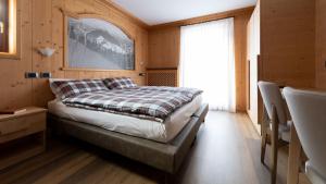 a bedroom with a bed and a window in a room at Hotel Compagnoni in Santa Caterina Valfurva