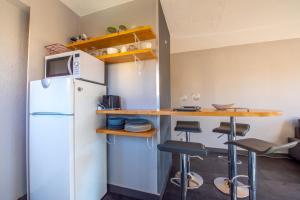 een keuken met een koelkast en een aanrecht met krukken bij Nice Apt Near Bouillabaisse Beach in Saint-Tropez