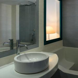 a white sink in a bathroom with a lamp at Veggera Beach Hotel in Perissa