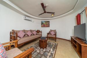 a living room with a couch and a tv at PrideInn Hotel Nyali in Mombasa