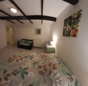 a bedroom with a bed and a couch in a room at Chambre indépendante à la campagne in Puycalvel Lautrec