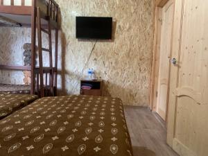 アルヒズにあるAquamarine Mini Hotelのベッドルーム1室(ベッド1台、壁にテレビ付)