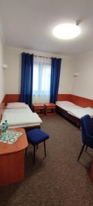 um quarto com duas camas e uma mesa e cadeiras em Motel Port 2000 em Mostki