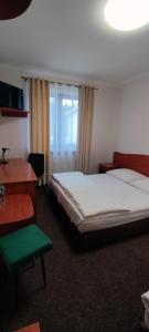 a bedroom with a bed and a desk and a window at Motel Port 2000 in Mostki