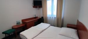 a bedroom with a bed and a desk and a television at Motel Port 2000 in Mostki