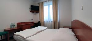 a bedroom with a bed and a desk and a window at Motel Port 2000 in Mostki