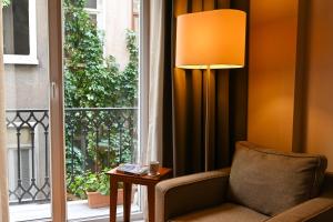 イスタンブールにあるNo11 ホテル ＆ アパートメンツの椅子とランプが備わる窓のある客室です。