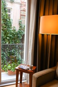una lámpara sentada en una mesa junto a una ventana en No11 Hotel & Apartments, en Estambul
