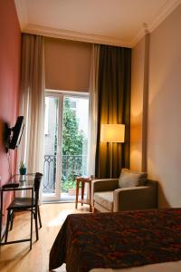イスタンブールにあるNo11 ホテル ＆ アパートメンツのベッド、ソファ、窓が備わるホテルルームです。